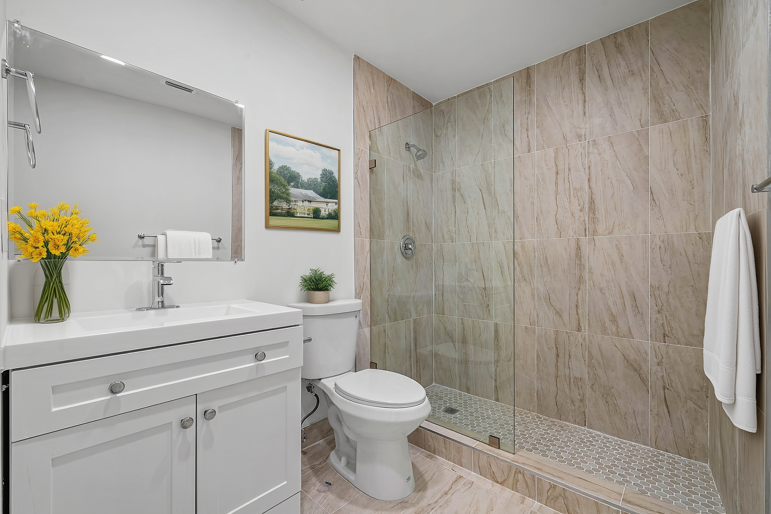 A bright bathroom featuring a white vanity with yellow flowers, a toilet, and a glass-enclosed shower with tiled walls.