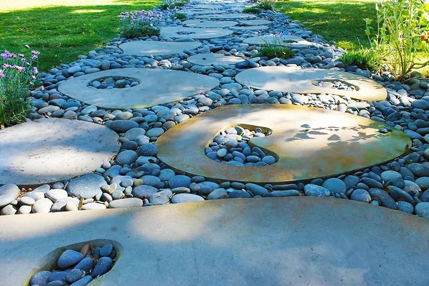 Circular stepping stones with decorative pebbles in a garden path.