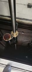 Metal pipes and a copper bowl mounted on a dark industrial ceiling, with wiring visible below.
