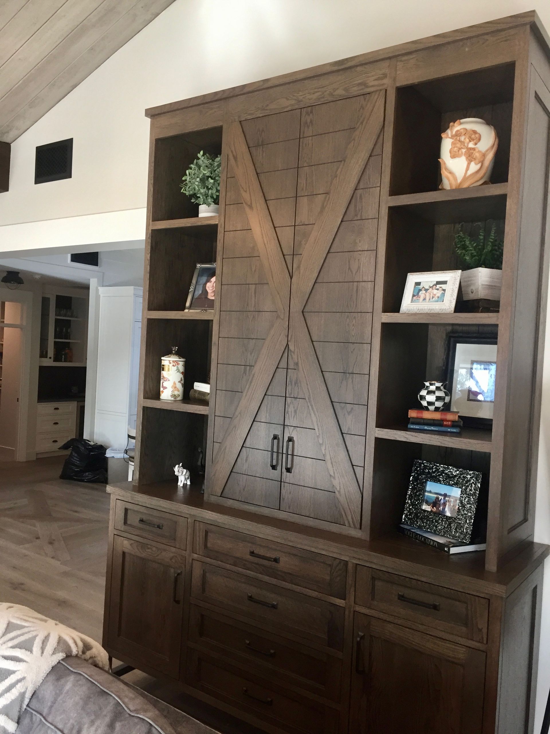 Wooden built-in cabinet with shelves, drawers, and decorative items in a living room
