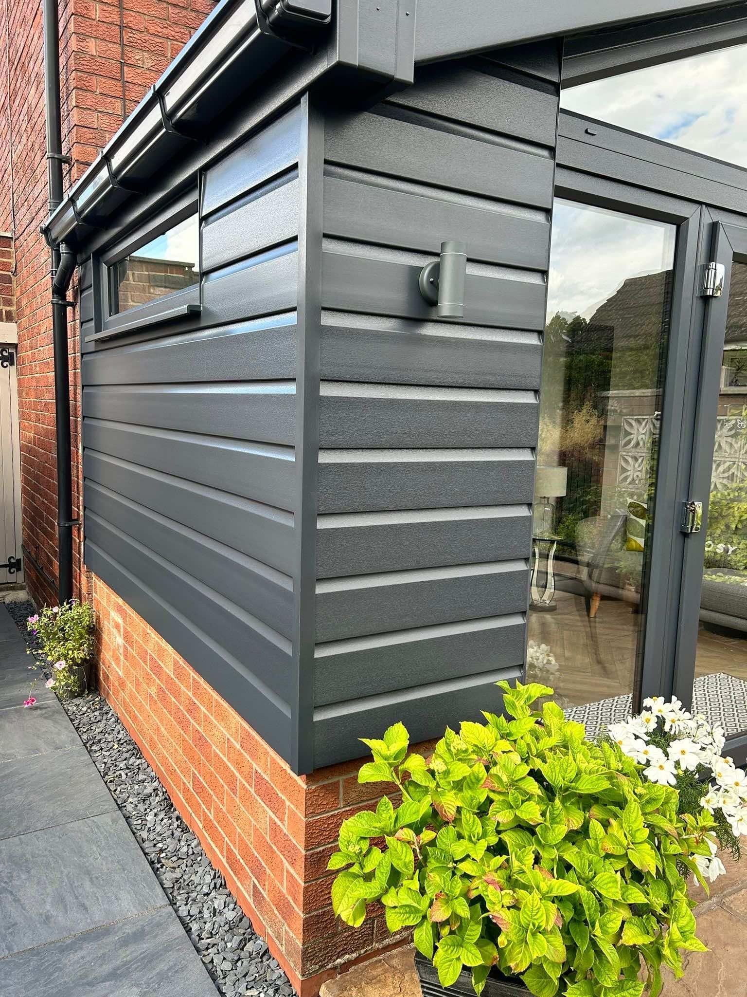 A close up of a gutter on the side of a house.