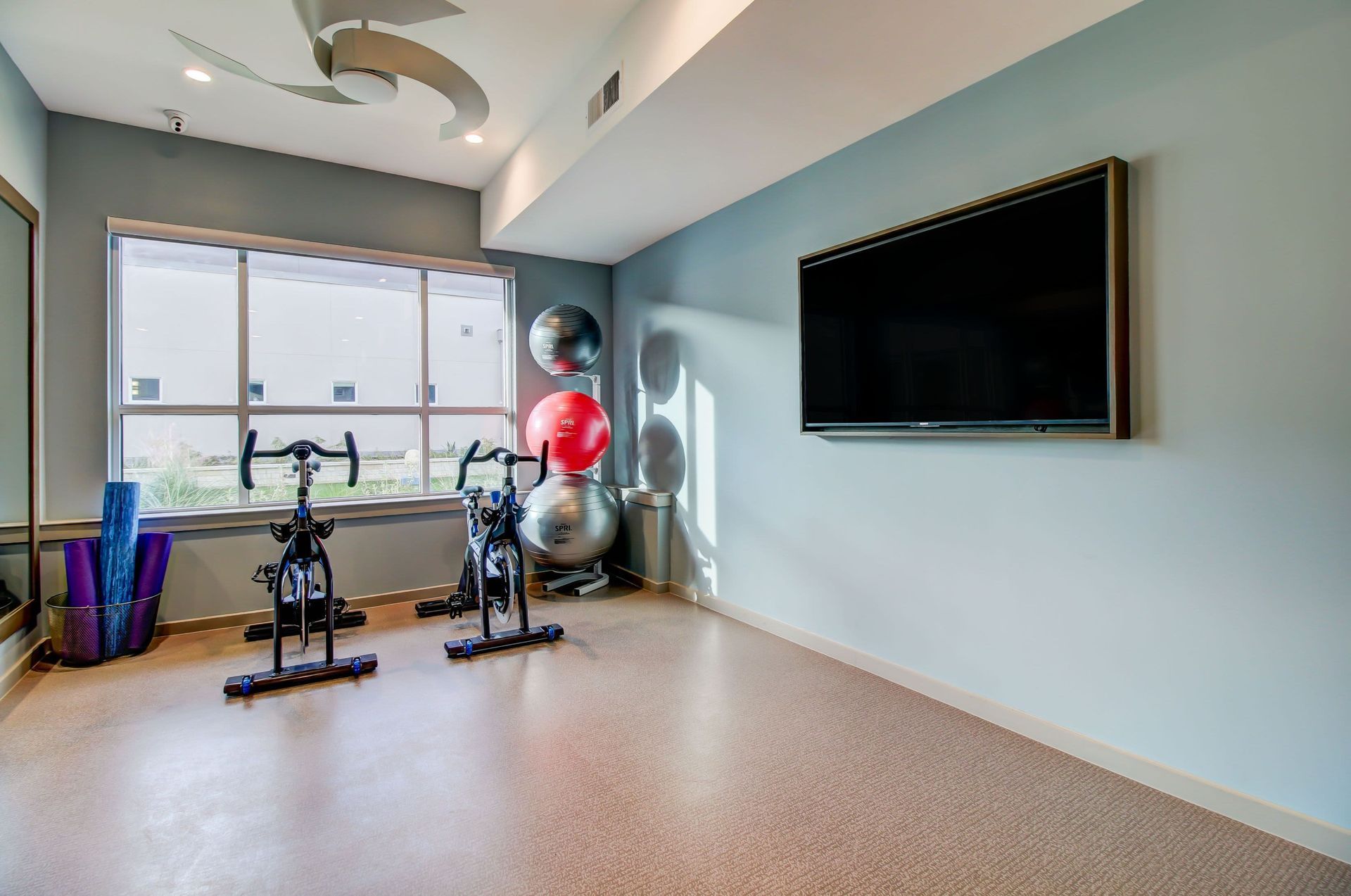 there are two exercise bikes and a flat screen tv in the room at Westerly 360 in Austin, TX.