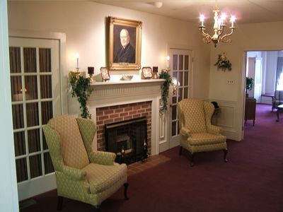 A living room with a couch , chairs , and a coffin.
