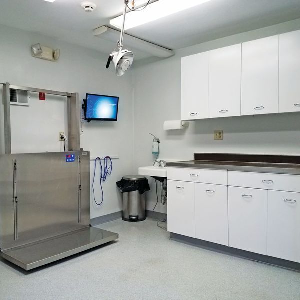 A kitchen with white cabinets and a tv on the wall