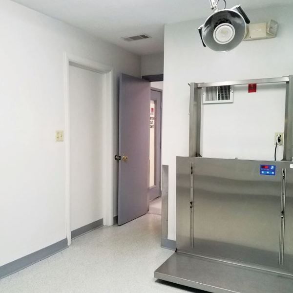 An empty room with a stainless steel door and a scale