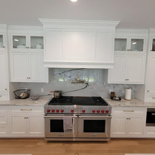 A kitchen with stainless steel appliances and white cabinets.