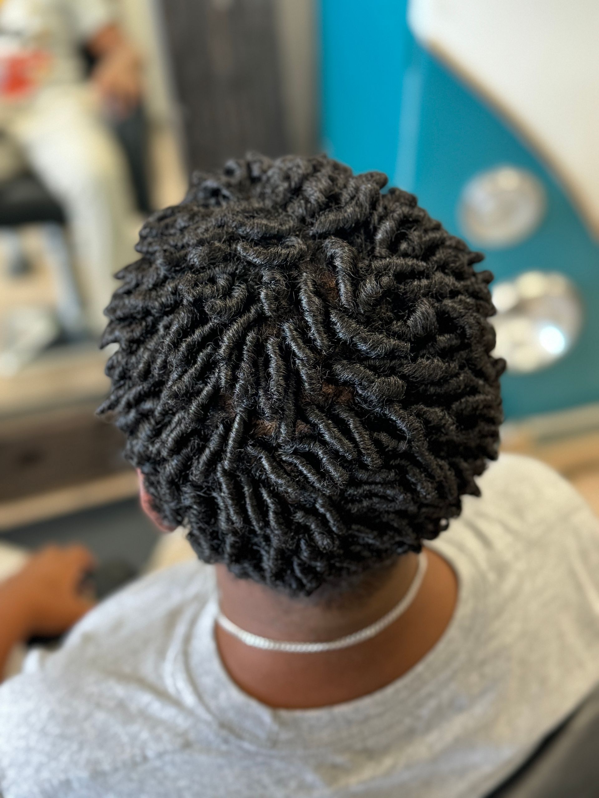 A man with dreadlocks is wearing a denim jacket