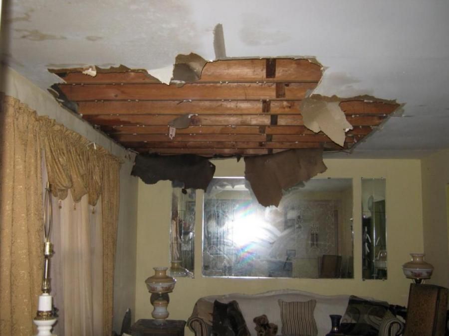 A living room with a ceiling that has been damaged by water