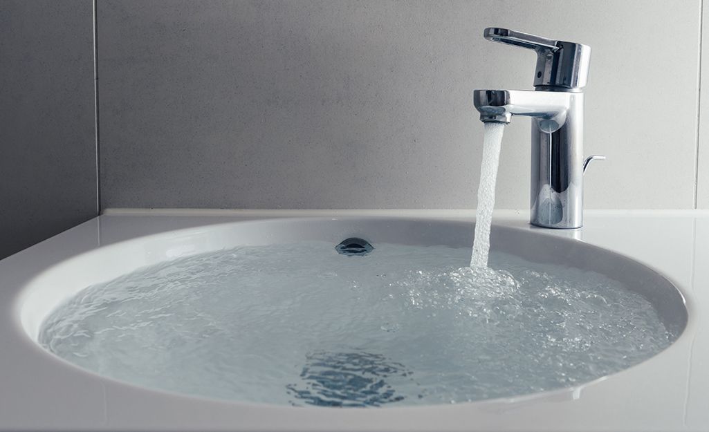 A bathroom sink with water running from a faucet.