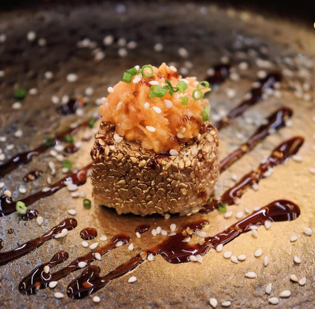 Un piatto di cibo con salsa e semi di sesamo sopra