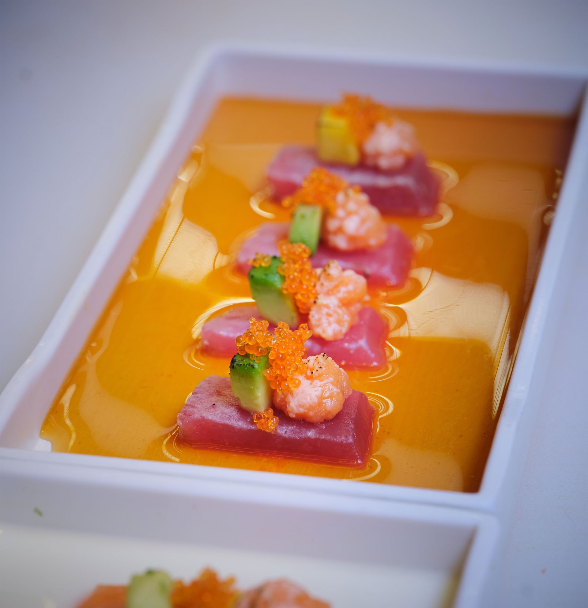 Un vassoio di cibo con gamberi e avocado sopra