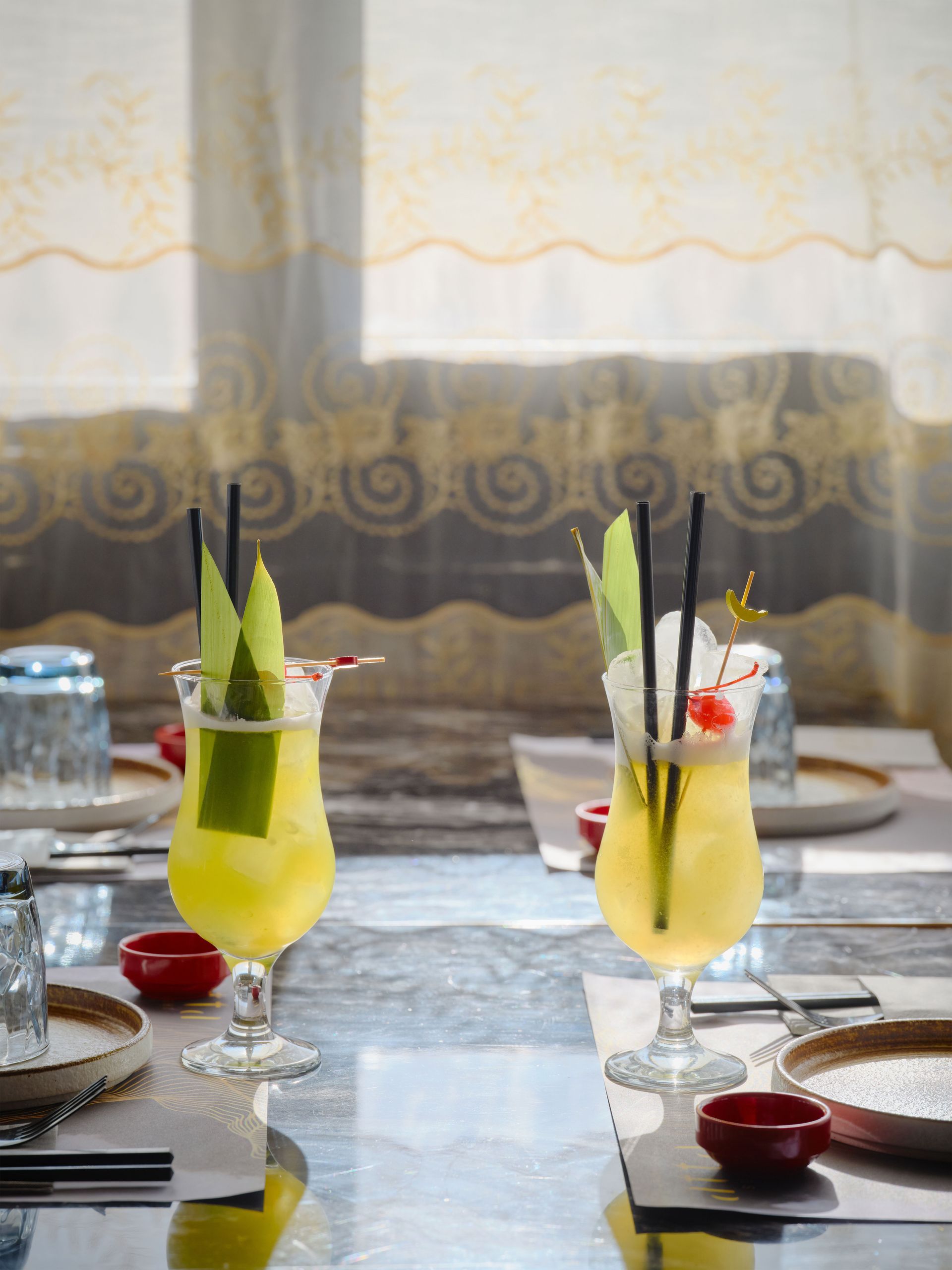 Due bevande con cannucce sono su un tavolo in un ristorante.