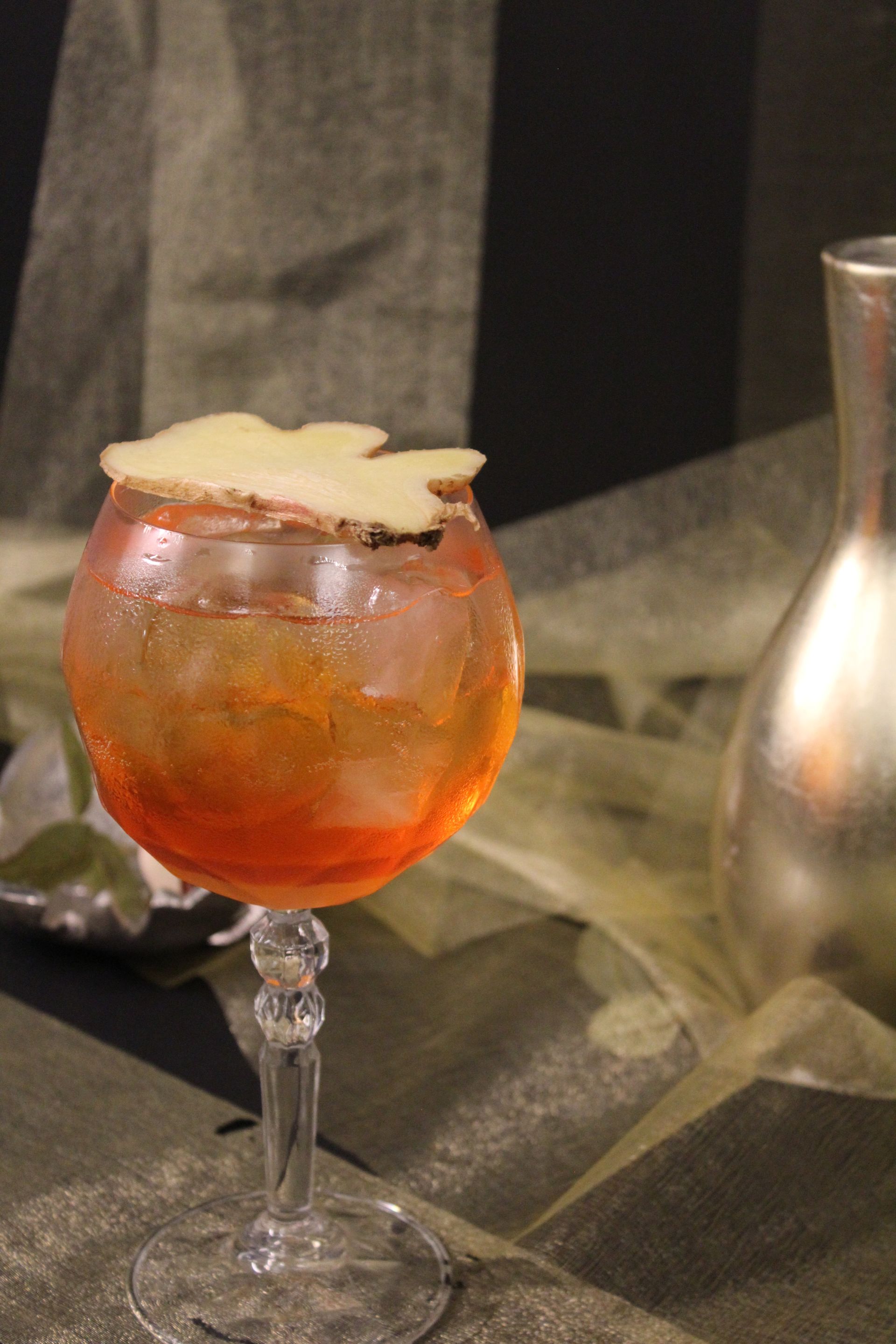 Un primo piano di un bicchiere di vino con un drink dentro, posto su un tavolo.