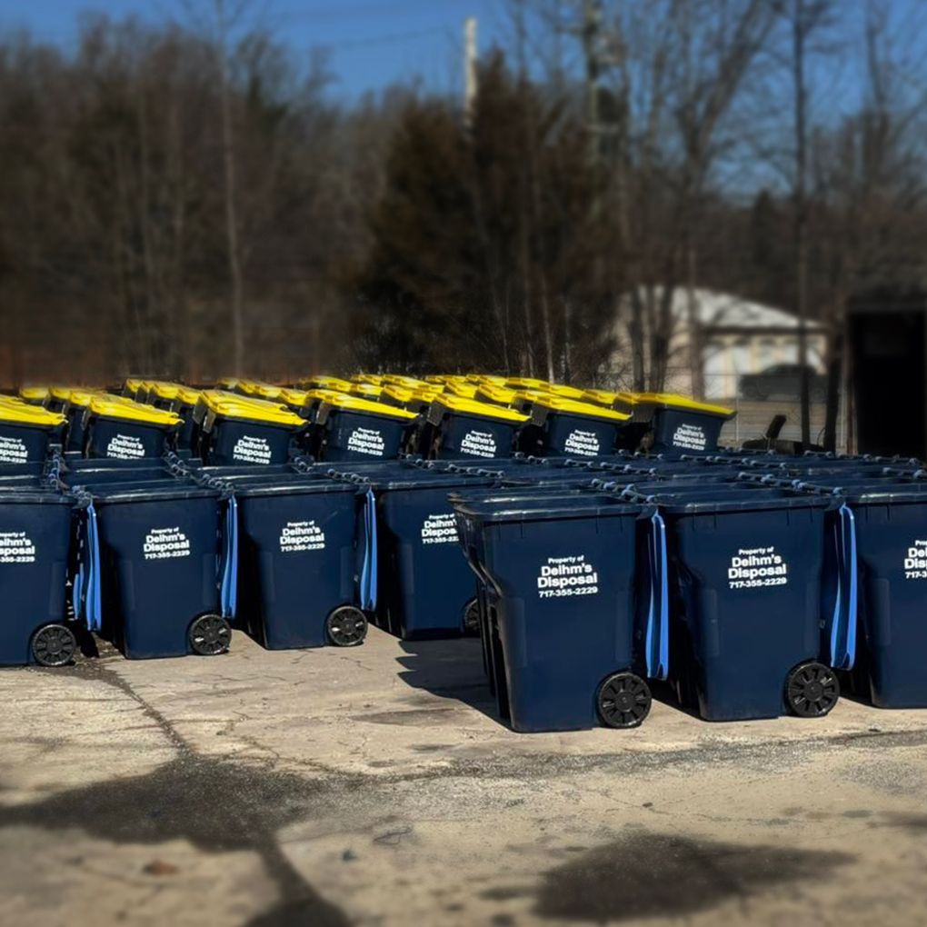 Deihm's Disposal of PA garbage truck is parked on the side of the road next to a house.