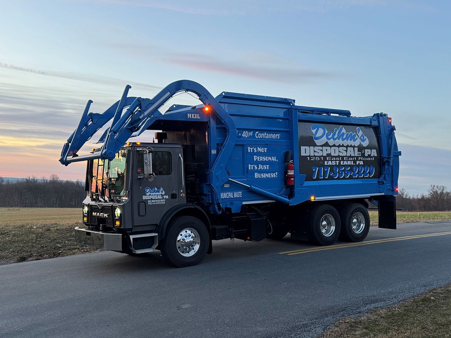 Deihm's Disposal of PA's blue garbage truck is parked on the side of the road