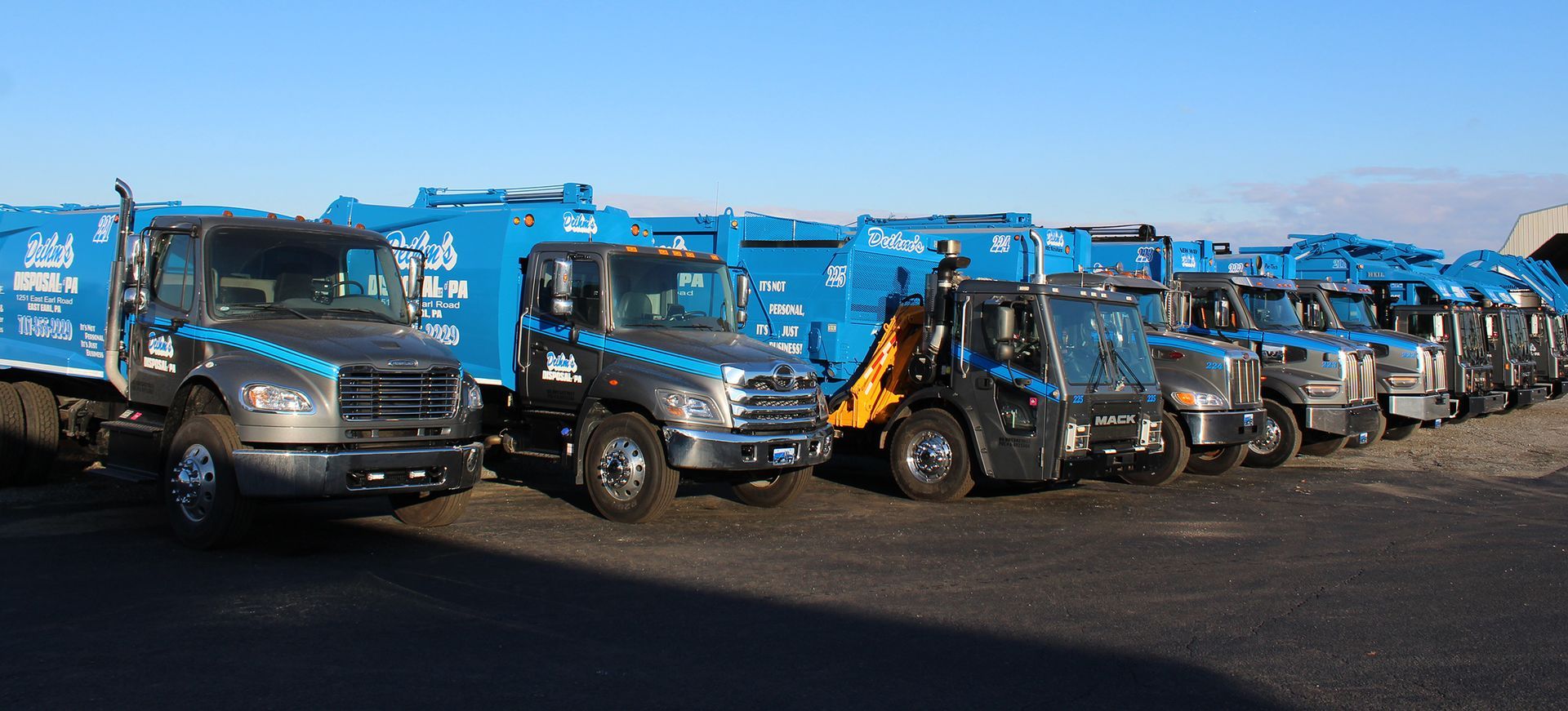Deihm's Disposal of PA's fleet of garbage trucks are parked in a parking lot.