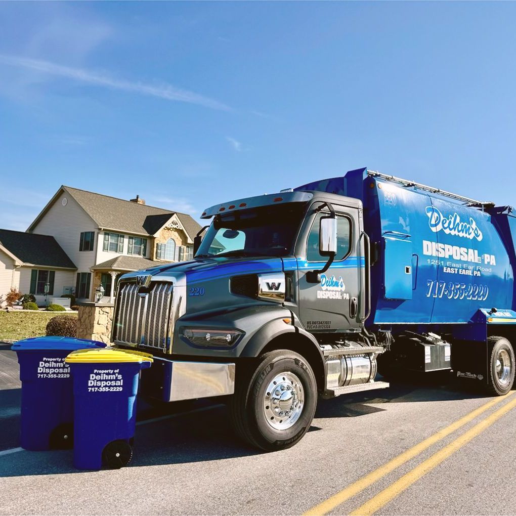 Deihm's Disposal of PA's blue garbage truck is parked on the side of the road