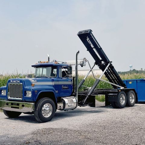 Deihm's Disposal of PA's blue mack dump truck is parked on the side of the road