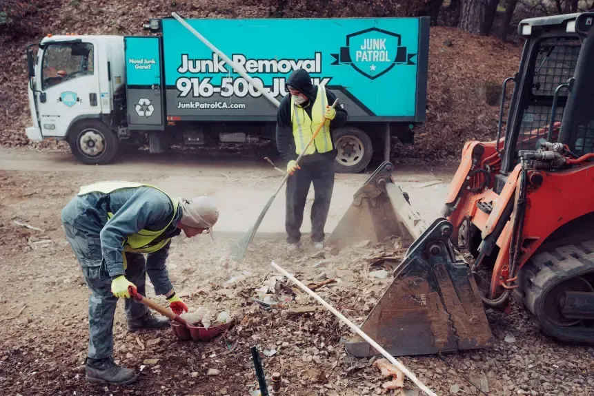 Two men are working in front of a junk removal truck.