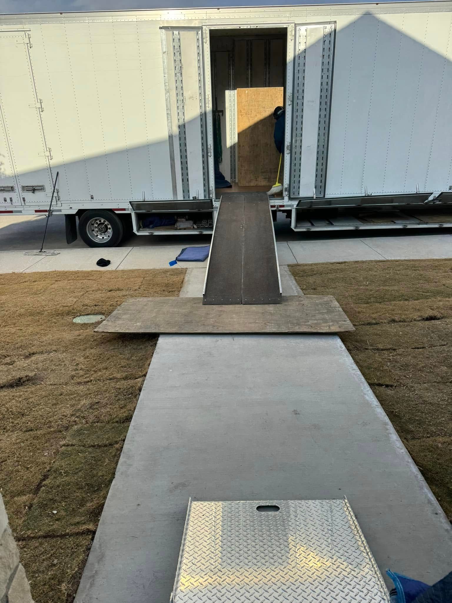 Three people are standing in front of a large window looking out.