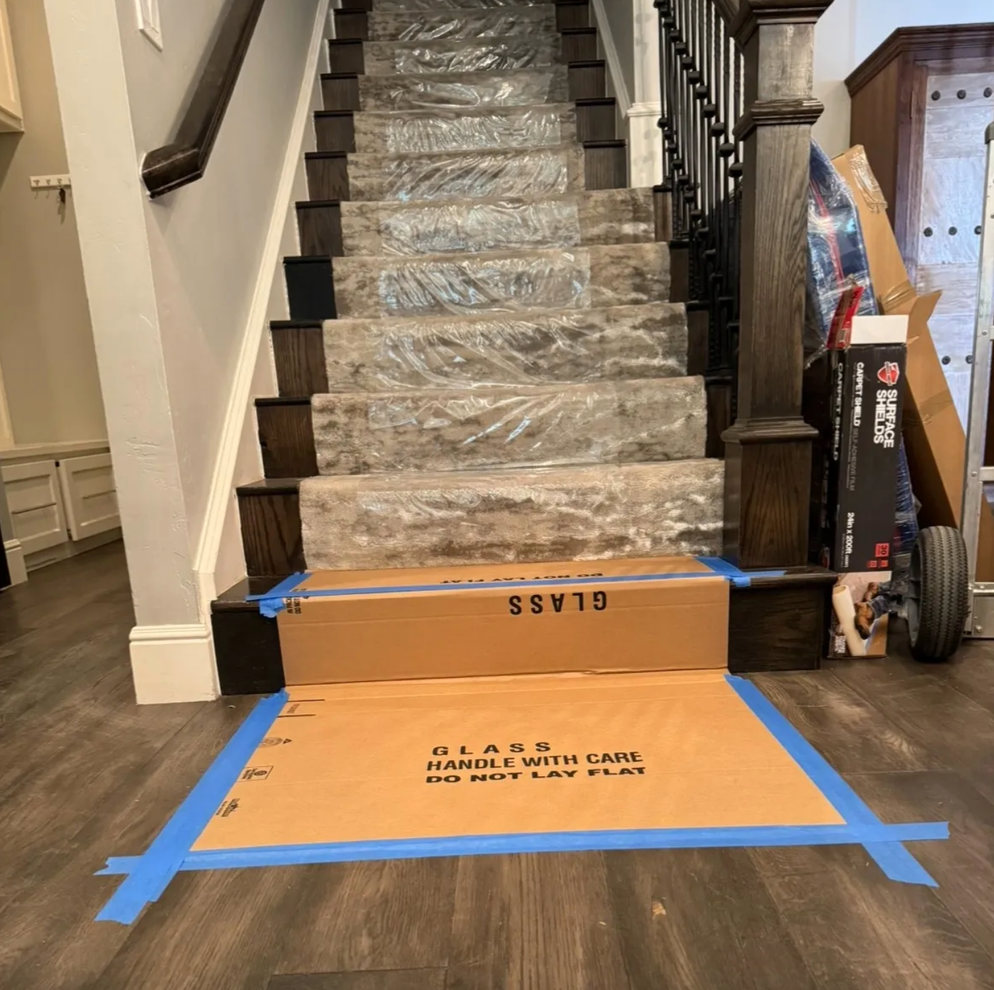 A staircase with a cardboard box that says glass on it