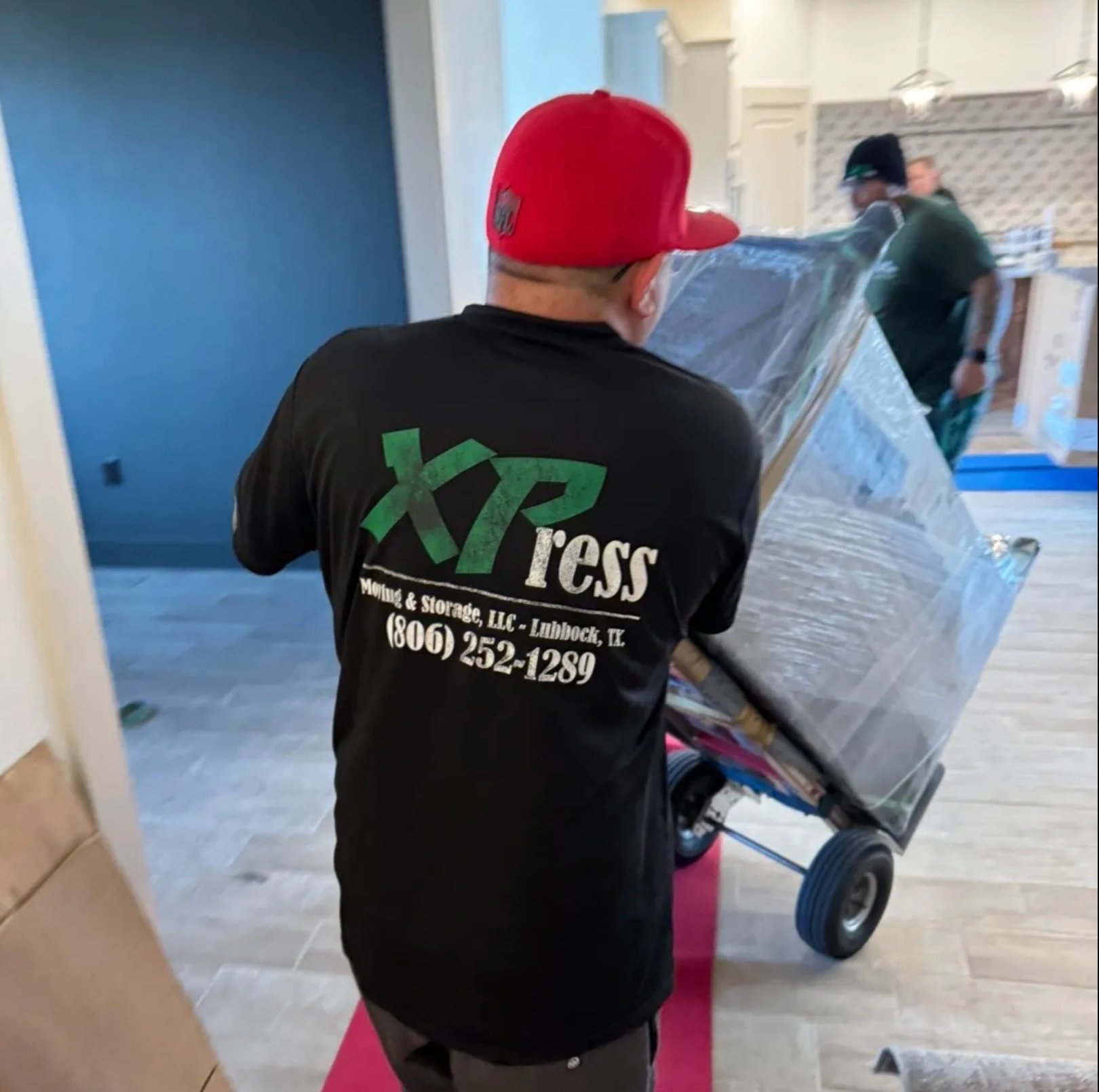 A white moving truck is parked on the side of the road in front of a house.
