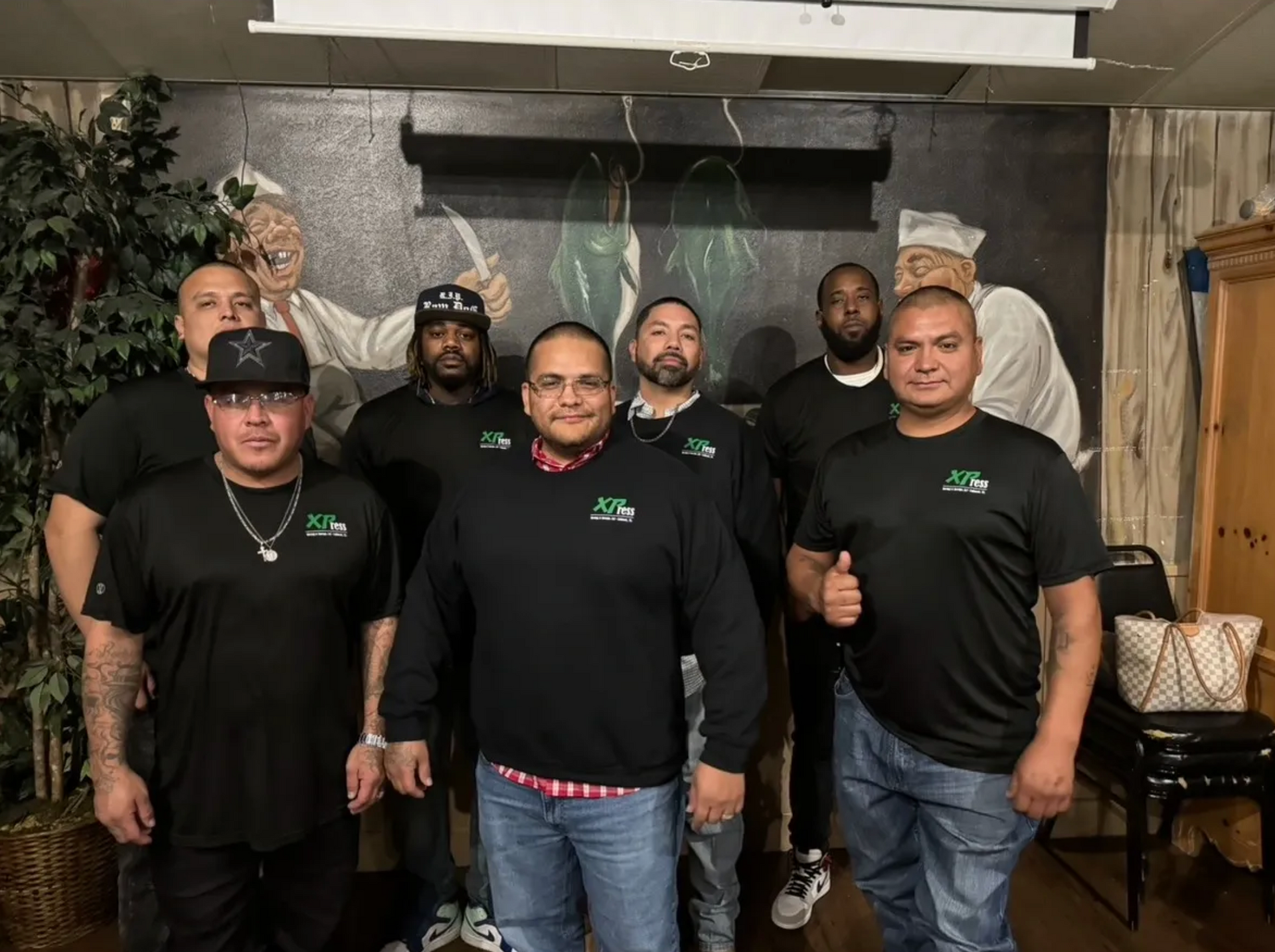 A group of men are posing for a picture in a room.