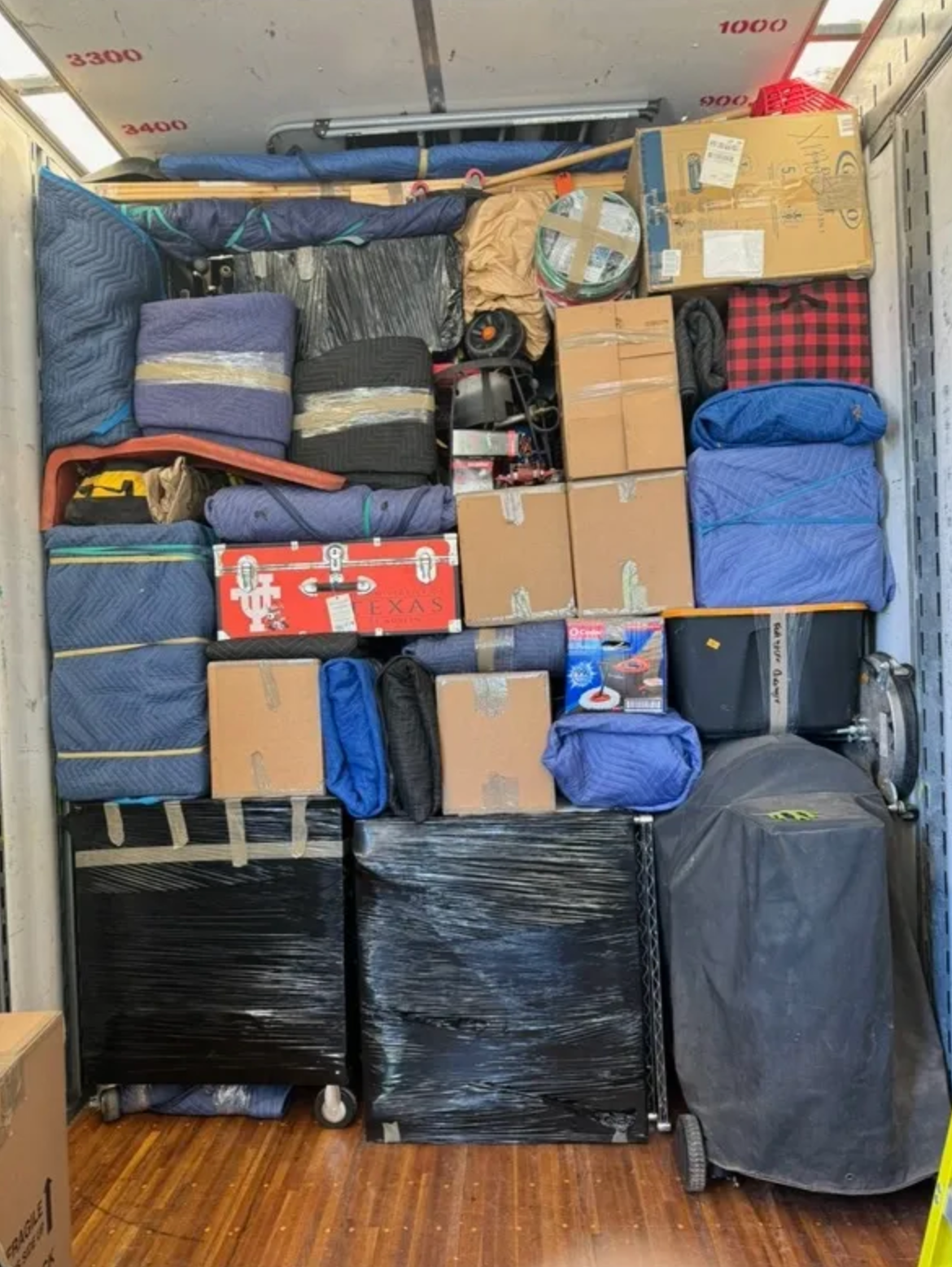 A moving truck filled with lots of boxes and luggage