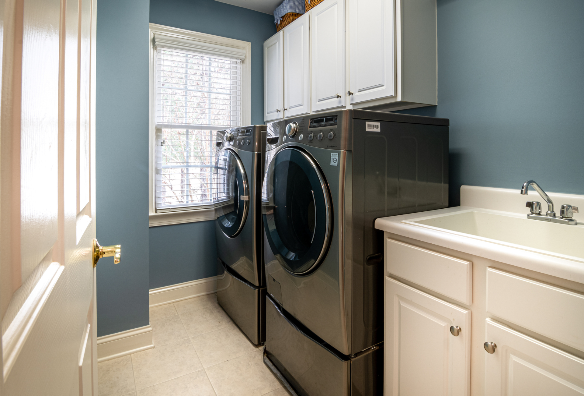 A laundry room with a washer and dryer and a sink.