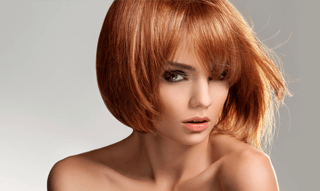 A lady with a short strawberry-blonde bob style
