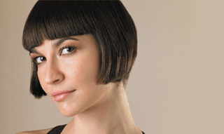 A lady with very short dark bobbed hair
