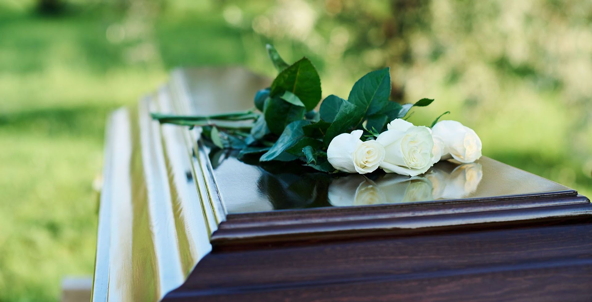 A wooden coffin with flowers on top of it in a funeral home.