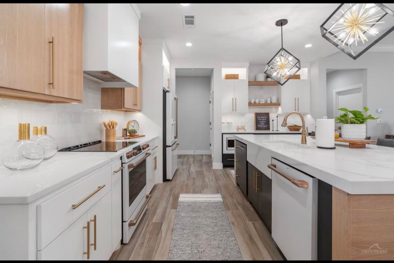 A kitchen with white cabinets , black appliances , and a large island.