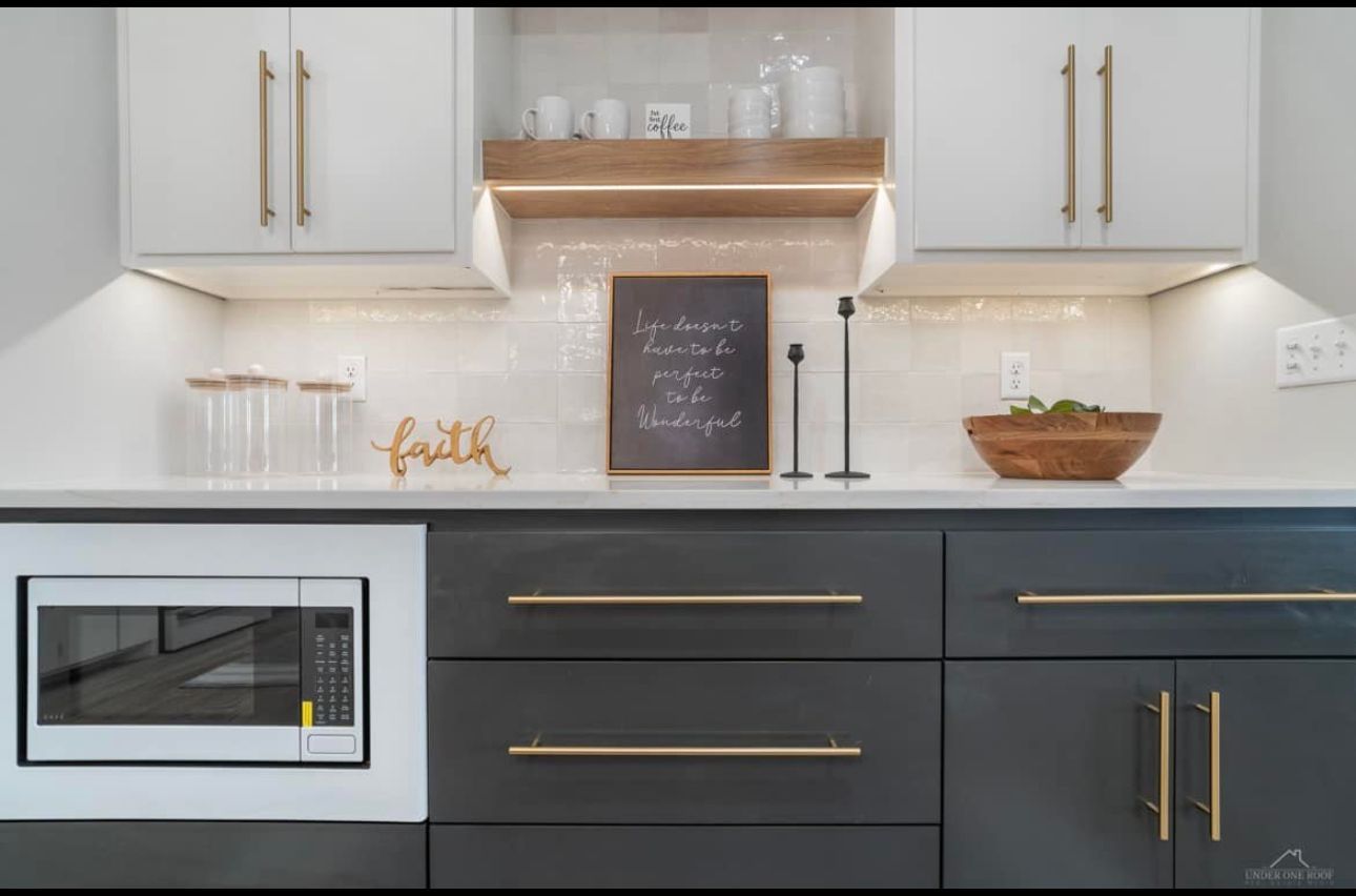 A kitchen with a microwave and a sign on the wall.