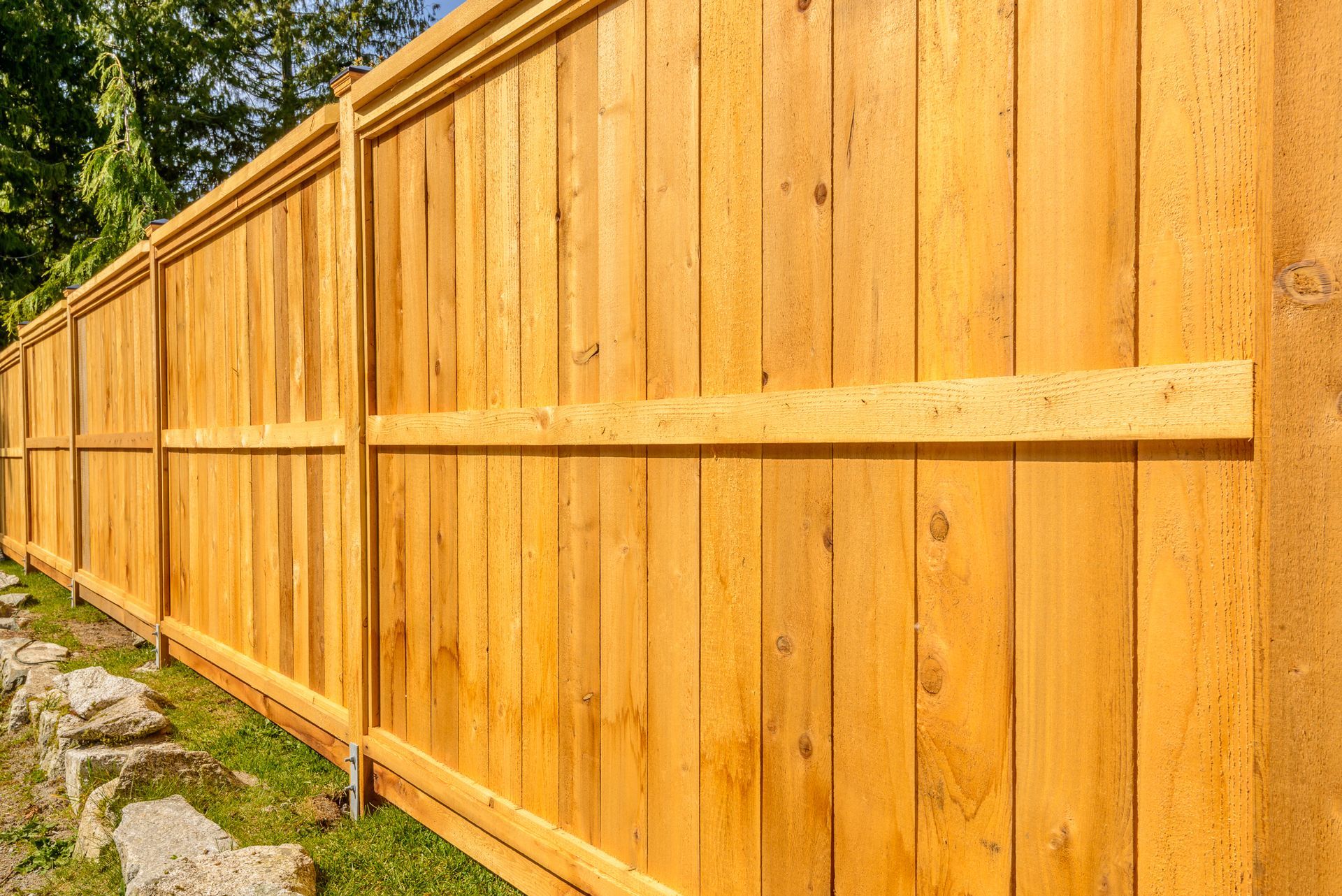 A wooden fence is sitting on top of a lush green field.