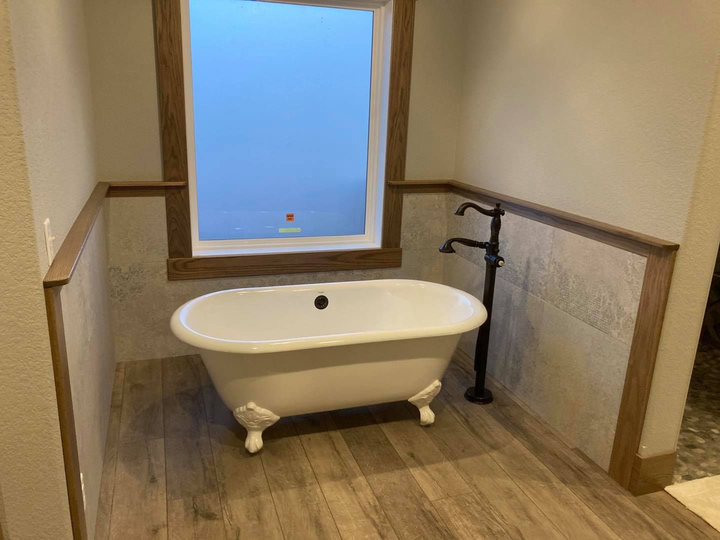 A bathtub is sitting in a bathroom next to a window.