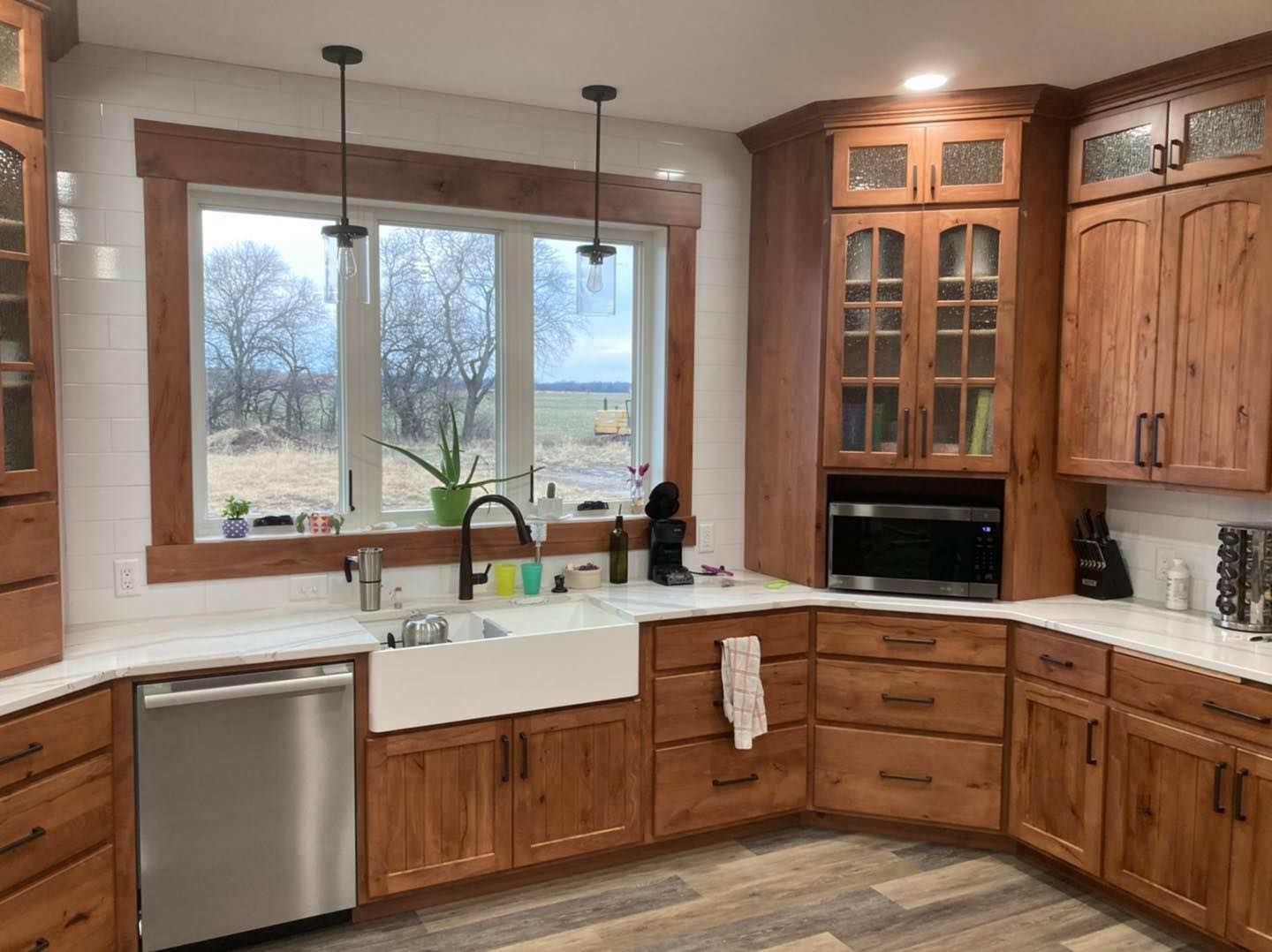 A kitchen with wooden cabinets , stainless steel appliances , a sink , and a window.