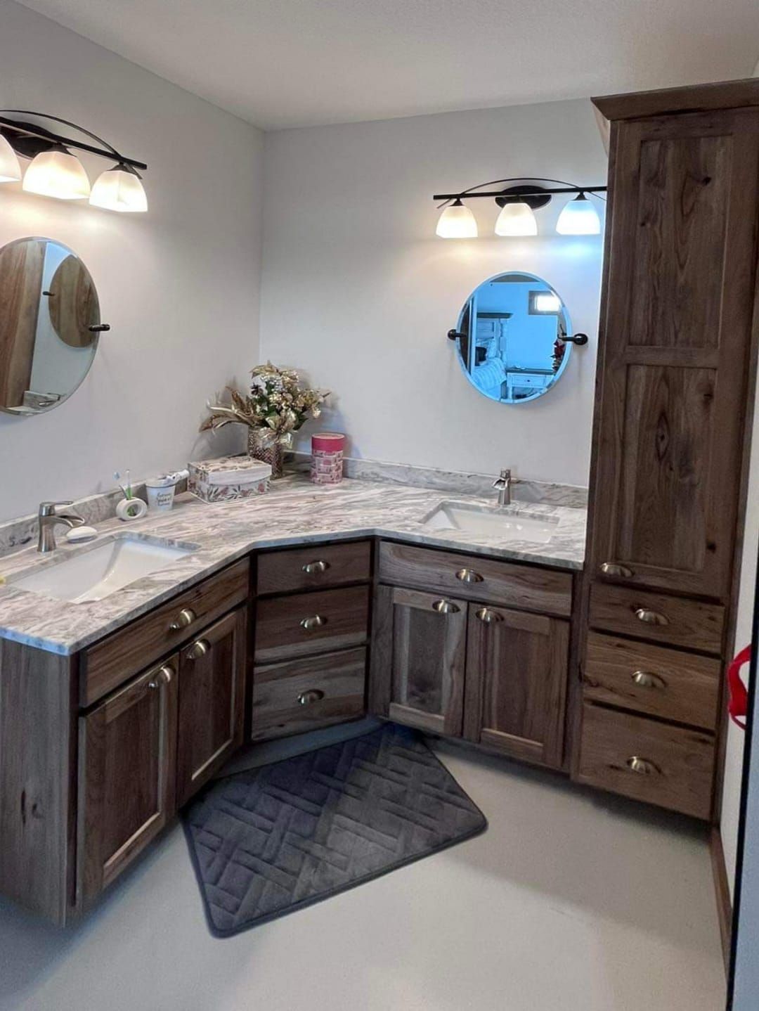 A bathroom with two sinks , a mirror and a rug.