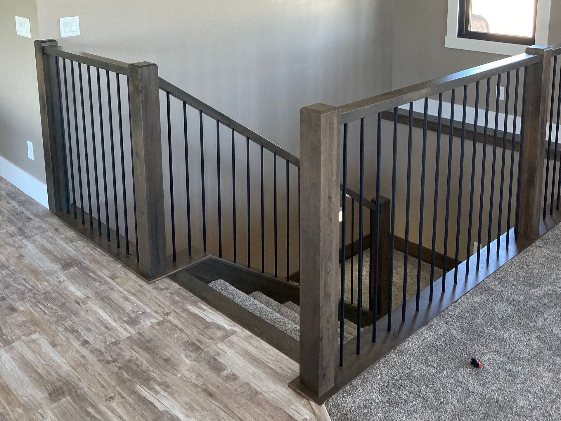 A staircase with a wooden railing and a metal railing in a house.