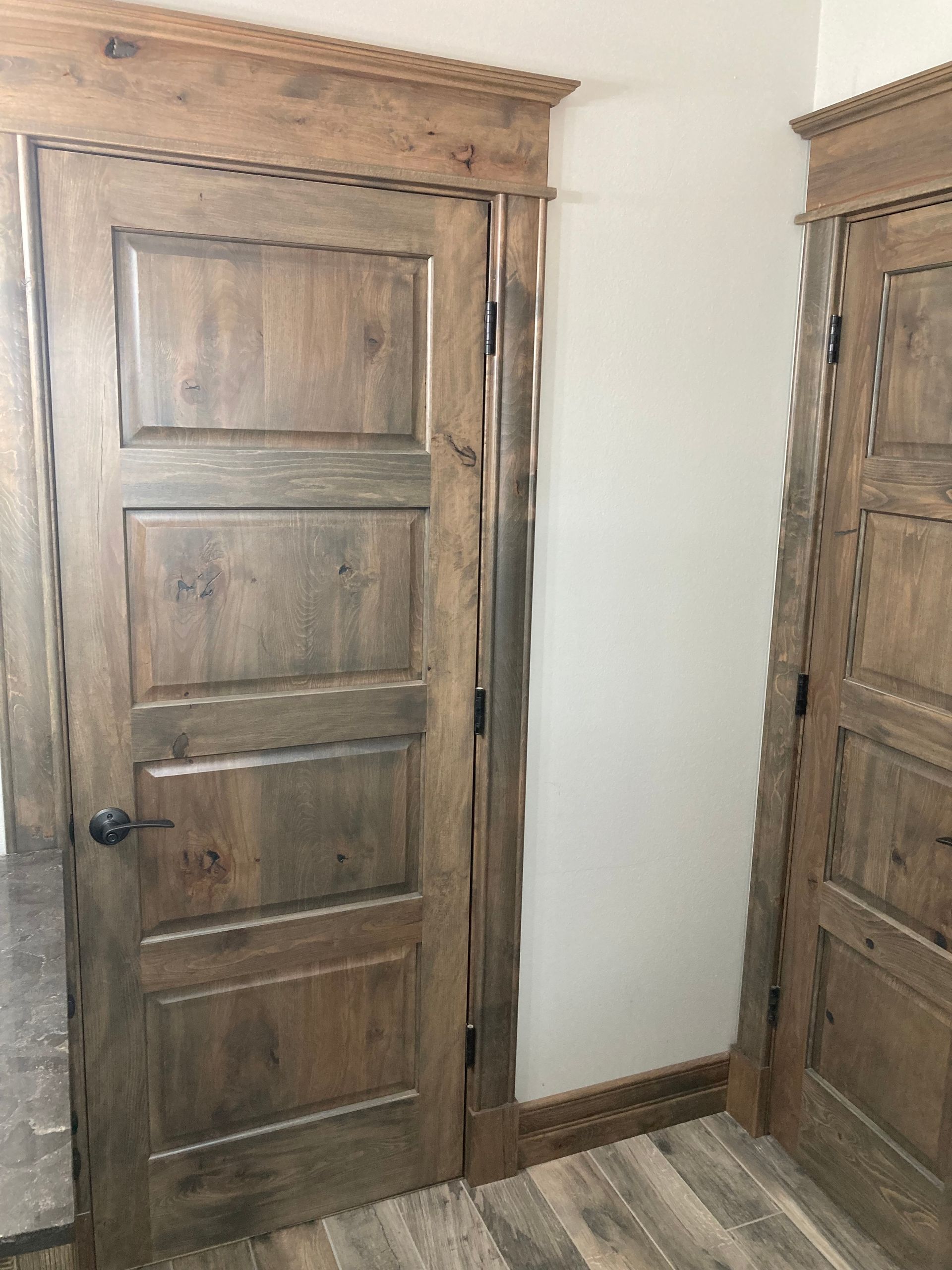 A wooden door in a room with a white wall