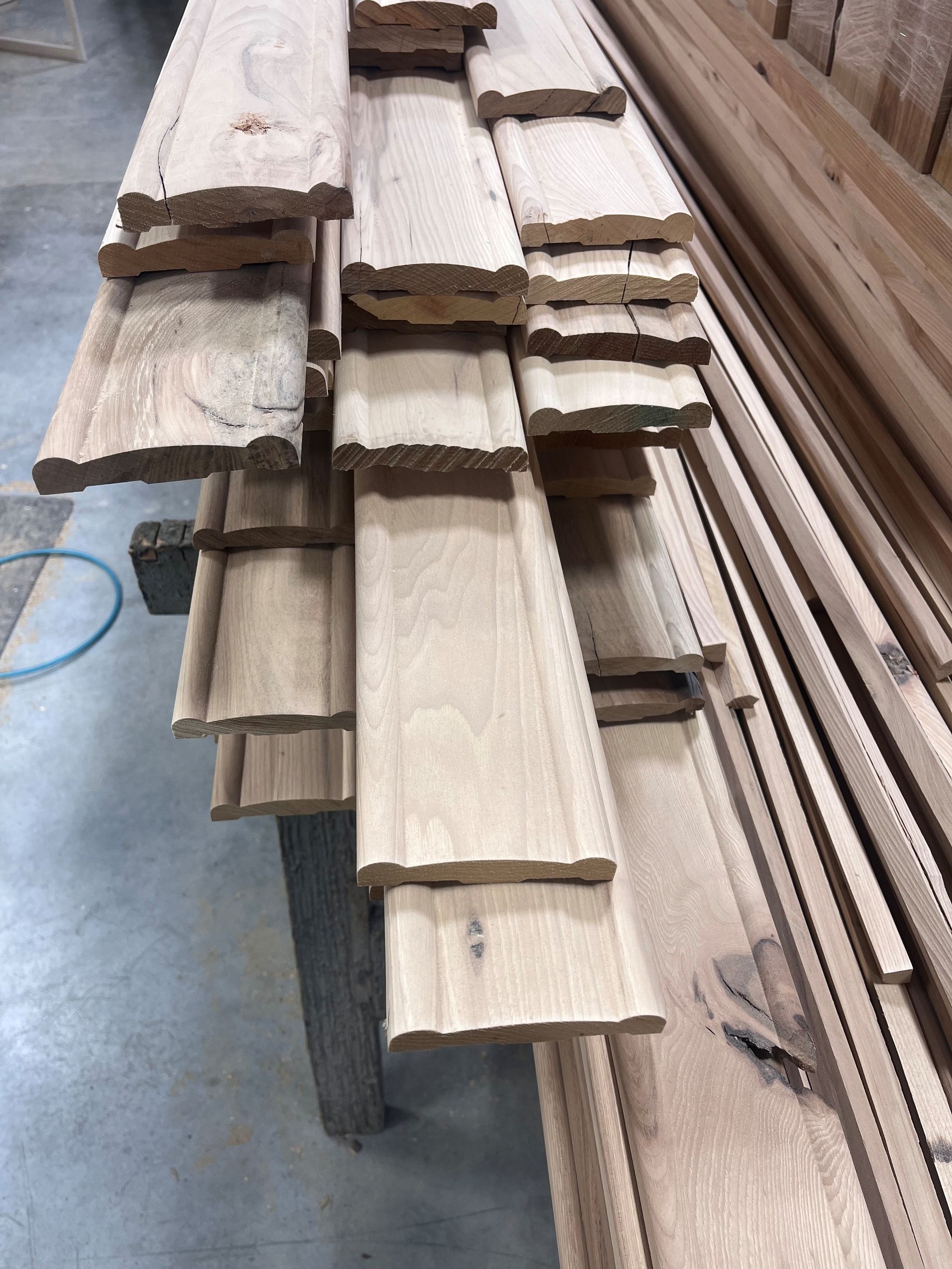 Wooden planks stacked, with a decorative edge, on a table.