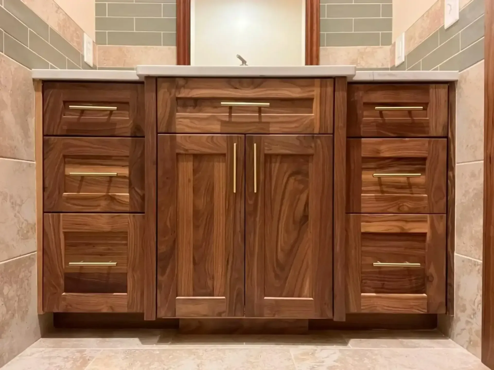 A bathroom vanity with wooden cabinets and drawers and a sink.