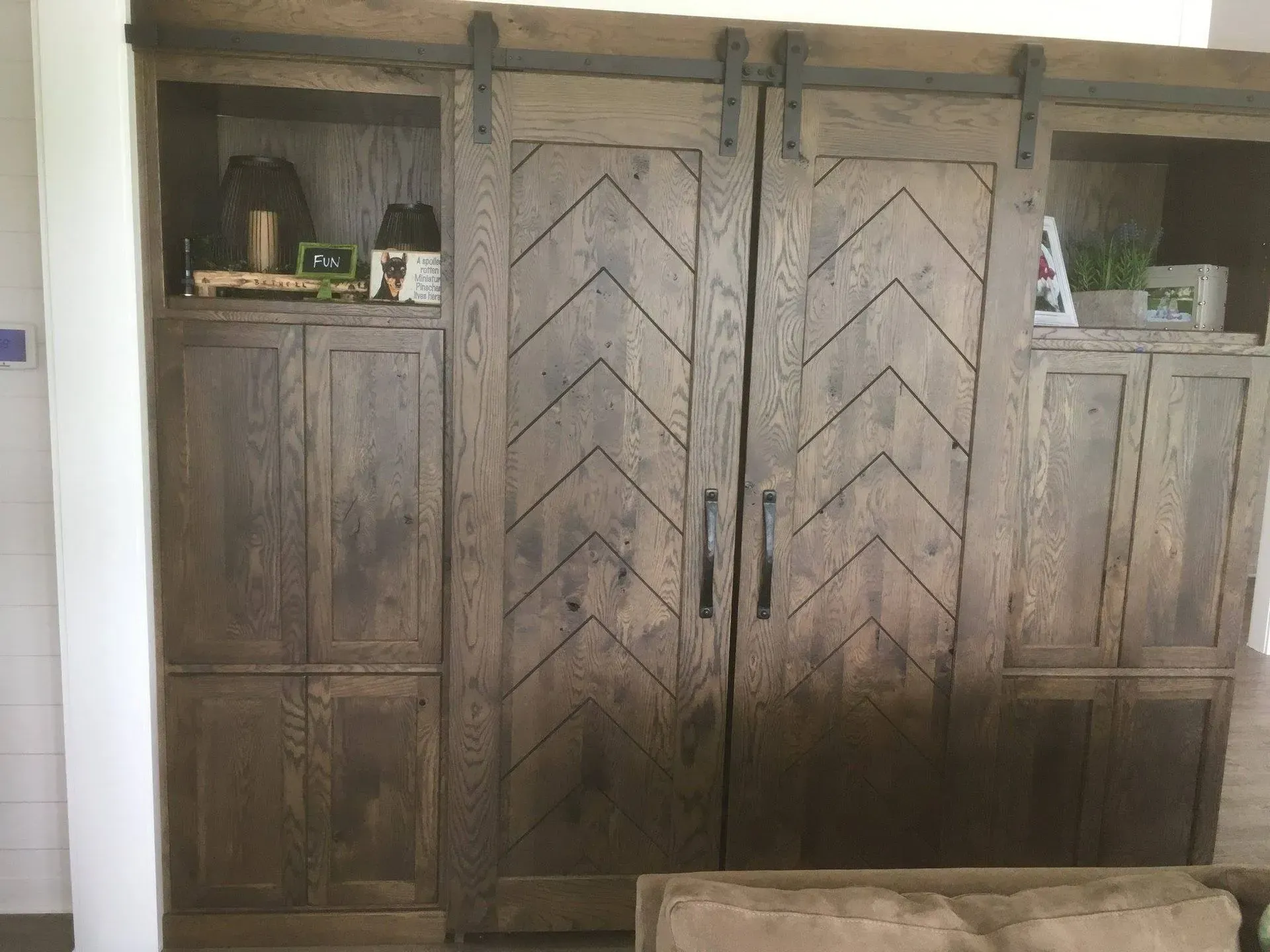 A living room with wooden cabinets and sliding barn doors.