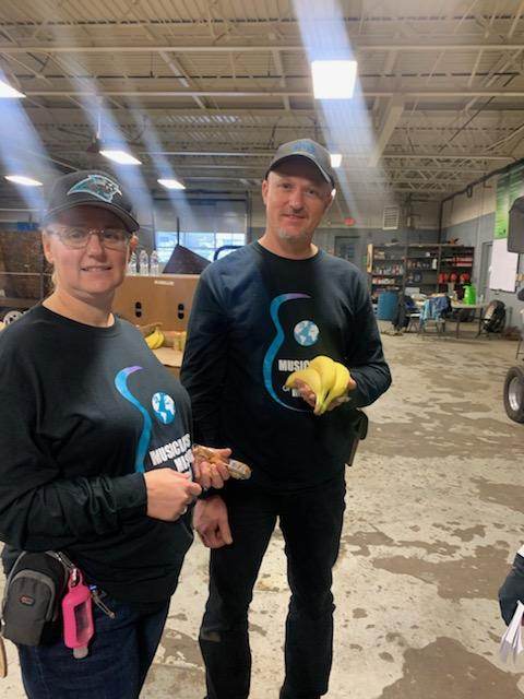 A man and a woman are standing next to each other in a garage.
