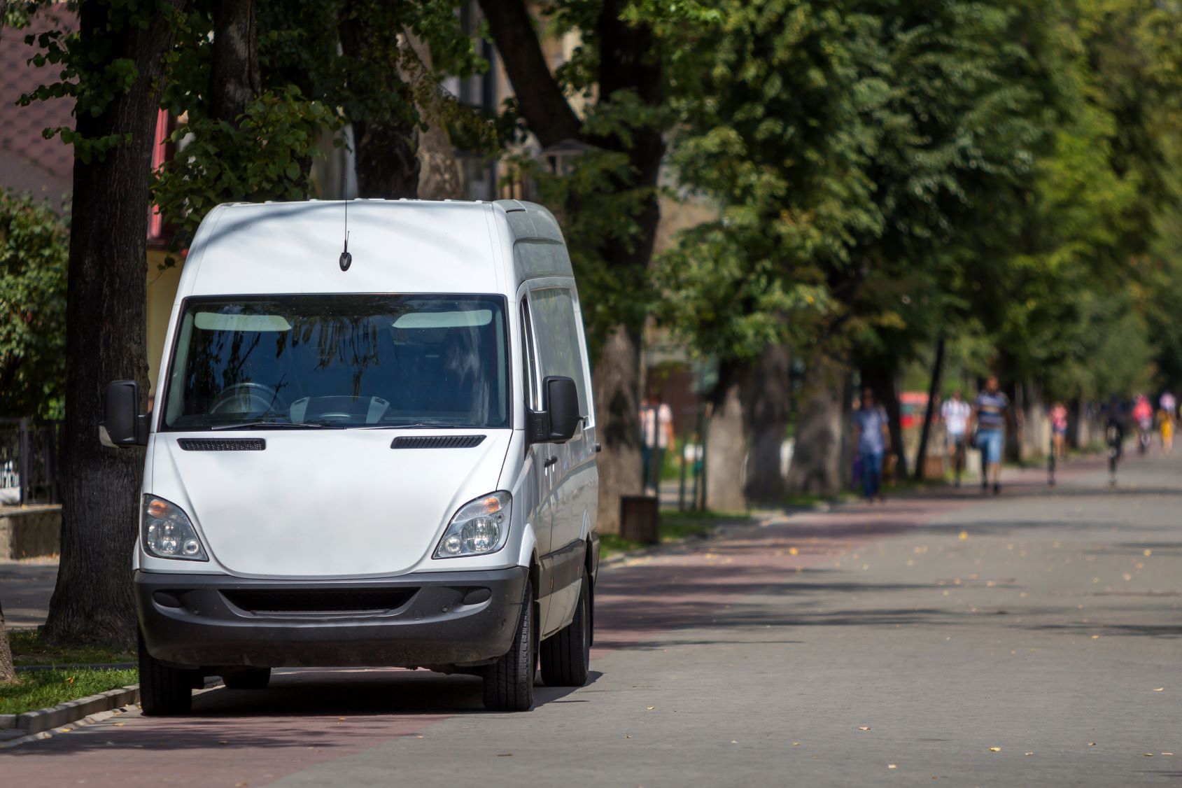 A white van is parked on the side of the road.