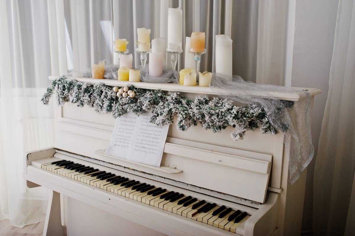 Elegant indoor memorial tribute with piano, candles, and framed photo in soft lighting, symbolizing