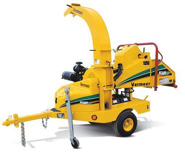 Yellow Vermeer wood chipper on a trailer, used for processing tree branches.