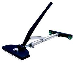 Black carpet stretcher with angled handle, metal frame, and green wheels.