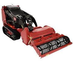 Red tracked compact utility loader with a soil conditioner attachment.