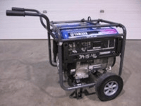 Yamaha generator with blue and black frame, wheels, and handle on a concrete surface.